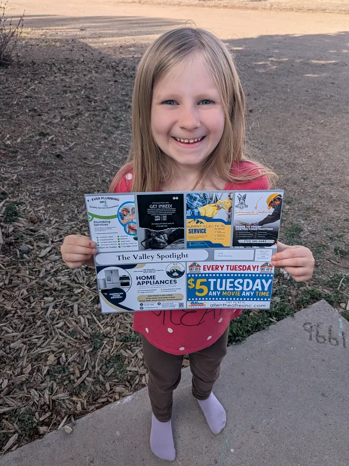 A happy neighbor holding a delivered co-op mailer